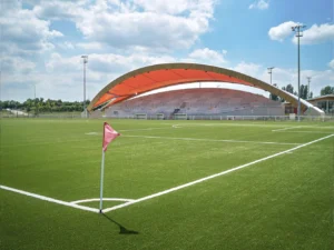 Tribune de stade couverte d'une toile tendue, vue depuis le terrain